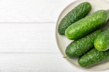 Ahşap arka planda salatalık. Arka planda bir parça salatalık. Taze organik yeşil salatalık turşusu. Vejetaryen. Salata malzemesi. Çiftlik sebzeleri. Sebzeleri bıçakla kes. Mesaj için yer var. Boşluğu kopyala