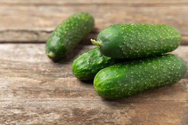 Ahşap arka planda salatalık. Arka planda bir parça salatalık. Taze organik yeşil salatalık turşusu. Vejetaryen. Salata malzemesi. Çiftlik sebzeleri. Sebzeleri bıçakla kes. Mesaj için yer var. Boşluğu kopyala