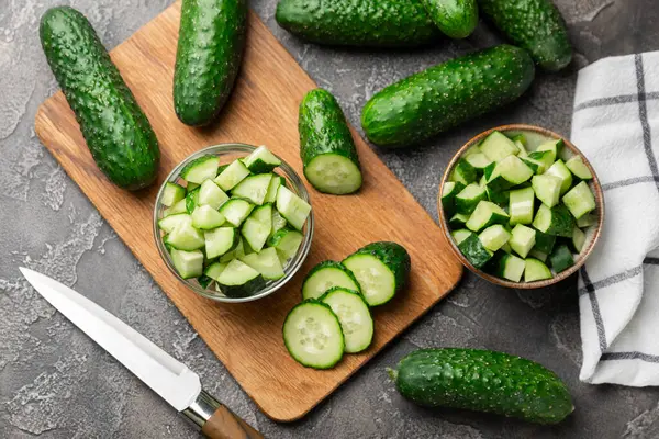 Ahşap arka planda salatalık. Arka planda bir parça salatalık. Taze organik yeşil salatalık turşusu. Vejetaryen. Salata malzemesi. Çiftlik sebzeleri. Sebzeleri bıçakla kes. Mesaj için yer var. Boşluğu kopyala