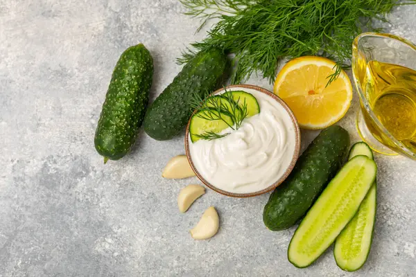 Ahşap bir masada salatalık kremalı tzatziki sosu. Tatar sosu. Geleneksel lezzetli aperatif. Yoğurt sosu. Tzatziki, salatalık, sarımsak, dereotu, limon, nane. Salata sosu. Kopya alanı.