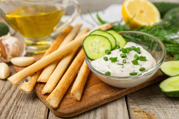 Ahşap bir masada salatalık kremalı tzatziki sosu. Tatar sosu. Geleneksel lezzetli aperatif. Yoğurt sosu. Tzatziki, salatalık, sarımsak, dereotu, limon, nane. Salata sosu. Kopya alanı.