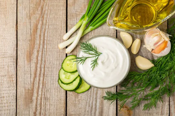 Ahşap bir masada salatalık kremalı tzatziki sosu. Tatar sosu. Geleneksel lezzetli aperatif. Yoğurt sosu. Tzatziki, salatalık, sarımsak, dereotu, limon, nane. Salata sosu. Kopya alanı.