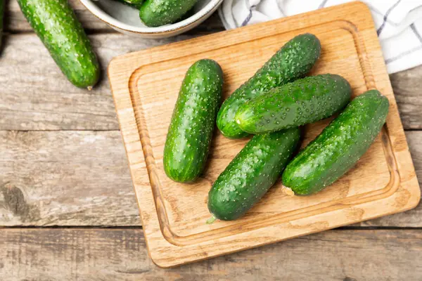 Ahşap arka planda salatalık. Arka planda bir parça salatalık. Taze organik yeşil salatalık turşusu. Vejetaryen. Salata malzemesi. Çiftlik sebzeleri. Sebzeleri bıçakla kes. Mesaj için yer var. Boşluğu kopyala