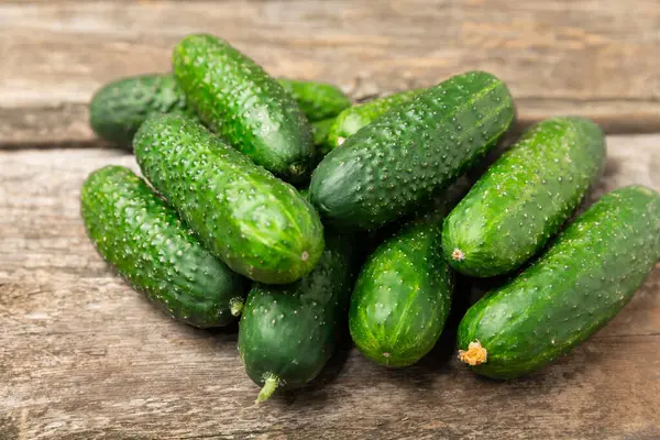 Ahşap arka planda salatalık. Arka planda bir parça salatalık. Taze organik yeşil salatalık turşusu. Vejetaryen. Salata malzemesi. Çiftlik sebzeleri. Sebzeleri bıçakla kes. Mesaj için yer var. Boşluğu kopyala