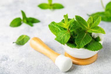 Ahşap zemin üzerinde havan ve kabuk ile taze nane. Melissa gider. Şifalı bitkiler, ilaç için havanda yeşil nane yaprakları. Mesaj için alan. Boşluğu kopyala.