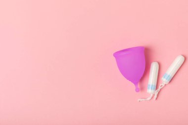 Aybaşı bardağı parlak bir arka planda. Hijyenik peçeteler, tamponlar ve regl kupası. Kritik günler, regl dönemi kavramı. Kadın hijyen ürünü. Kadın sağlığı kavramı. Adet öncesi sendromu. Boşluğu kopyala