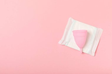 Aybaşı bardağı parlak bir arka planda. Hijyenik peçeteler, tamponlar ve regl kupası. Kritik günler, regl dönemi kavramı. Kadın hijyen ürünü. Kadın sağlığı kavramı. Adet öncesi sendromu. Boşluğu kopyala