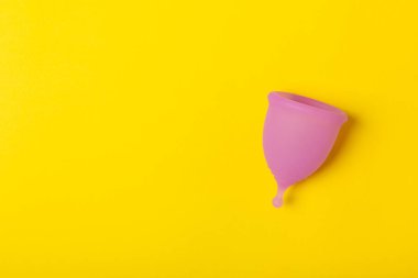 Aybaşı bardağı parlak bir arka planda. Hijyenik peçeteler, tamponlar ve regl kupası. Kritik günler, regl dönemi kavramı. Kadın hijyen ürünü. Kadın sağlığı kavramı. Adet öncesi sendromu. Boşluğu kopyala