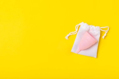 Aybaşı bardağı parlak bir arka planda. Hijyenik peçeteler, tamponlar ve regl kupası. Kritik günler, regl dönemi kavramı. Kadın hijyen ürünü. Kadın sağlığı kavramı. Adet öncesi sendromu. Boşluğu kopyala