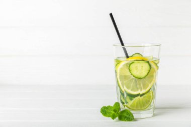 Salatalık suyu, limon, nane ve ahşap bir masada. İçme bardağında dilimlenmiş salatalık ile karıştırılmış su. Tonik ferahlatıcı bir içecek. Salatalık limonata. Doğal soğutma içeceği. Boşluğu kopyala.