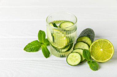 Salatalık suyu, limon, nane ve ahşap bir masada. İçme bardağında dilimlenmiş salatalık ile karıştırılmış su. Tonik ferahlatıcı bir içecek. Salatalık limonata. Doğal soğutma içeceği. Boşluğu kopyala.
