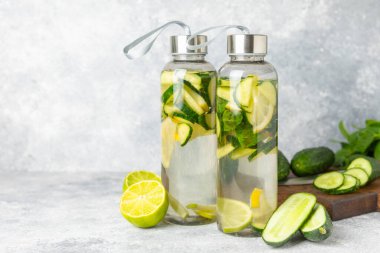 Salatalık suyu, limon, nane ve ahşap bir masada. İçme bardağında dilimlenmiş salatalık ile karıştırılmış su. Tonik ferahlatıcı bir içecek. Salatalık limonata. Doğal soğutma içeceği. Boşluğu kopyala.