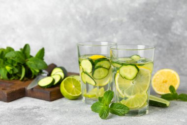 Salatalık suyu, limon, nane ve ahşap bir masada. İçme bardağında dilimlenmiş salatalık ile karıştırılmış su. Tonik ferahlatıcı bir içecek. Salatalık limonata. Doğal soğutma içeceği. Boşluğu kopyala.
