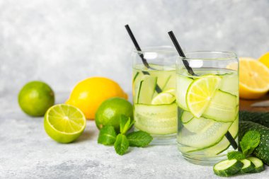 Salatalık suyu, limon, nane ve ahşap bir masada. İçme bardağında dilimlenmiş salatalık ile karıştırılmış su. Tonik ferahlatıcı bir içecek. Salatalık limonata. Doğal soğutma içeceği. Boşluğu kopyala.