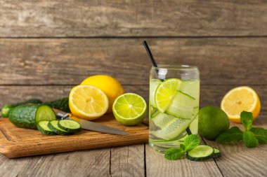 Salatalık suyu, limon, nane ve ahşap bir masada. İçme bardağında dilimlenmiş salatalık ile karıştırılmış su. Tonik ferahlatıcı bir içecek. Salatalık limonata. Doğal soğutma içeceği. Boşluğu kopyala.