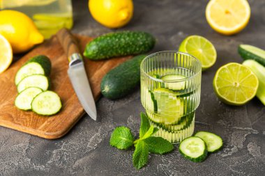 Salatalık suyu, limon, nane ve ahşap bir masada. İçme bardağında dilimlenmiş salatalık ile karıştırılmış su. Tonik ferahlatıcı bir içecek. Salatalık limonata. Doğal soğutma içeceği. Boşluğu kopyala.