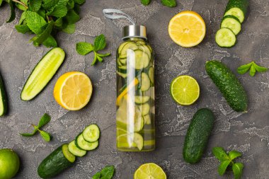 Salatalık suyu, limon, nane ve ahşap bir masada. İçme bardağında dilimlenmiş salatalık ile karıştırılmış su. Tonik ferahlatıcı bir içecek. Salatalık limonata. Doğal soğutma içeceği. Boşluğu kopyala.