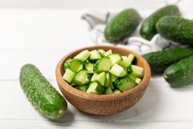 Ahşap arka planda salatalık. Arka planda bir parça salatalık. Taze organik yeşil salatalık turşusu. Vejetaryen. Salata malzemesi. Çiftlik sebzeleri. Sebzeleri bıçakla kes. Mesaj için yer var. Boşluğu kopyala