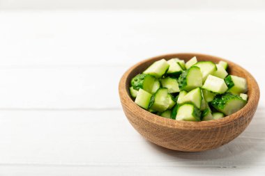 Ahşap arka planda salatalık. Arka planda bir parça salatalık. Taze organik yeşil salatalık turşusu. Vejetaryen. Salata malzemesi. Çiftlik sebzeleri. Sebzeleri bıçakla kes. Mesaj için yer var. Boşluğu kopyala