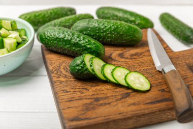 Ahşap arka planda salatalık. Arka planda bir parça salatalık. Taze organik yeşil salatalık turşusu. Vejetaryen. Salata malzemesi. Çiftlik sebzeleri. Sebzeleri bıçakla kes. Mesaj için yer var. Boşluğu kopyala