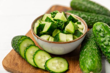 Ahşap arka planda salatalık. Arka planda bir parça salatalık. Taze organik yeşil salatalık turşusu. Vejetaryen. Salata malzemesi. Çiftlik sebzeleri. Sebzeleri bıçakla kes. Mesaj için yer var. Boşluğu kopyala