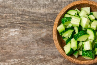 Ahşap arka planda salatalık. Arka planda bir parça salatalık. Taze organik yeşil salatalık turşusu. Vejetaryen. Salata malzemesi. Çiftlik sebzeleri. Sebzeleri bıçakla kes. Mesaj için yer var. Boşluğu kopyala
