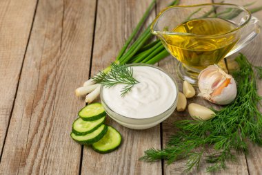 Ahşap bir masada salatalık kremalı tzatziki sosu. Tatar sosu. Geleneksel lezzetli aperatif. Yoğurt sosu. Tzatziki, salatalık, sarımsak, dereotu, limon, nane. Salata sosu. Kopya alanı.