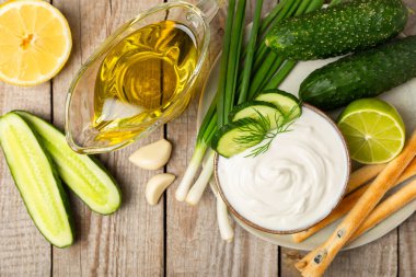Ahşap bir masada salatalık kremalı tzatziki sosu. Tatar sosu. Geleneksel lezzetli aperatif. Yoğurt sosu. Tzatziki, salatalık, sarımsak, dereotu, limon, nane. Salata sosu. Kopya alanı.