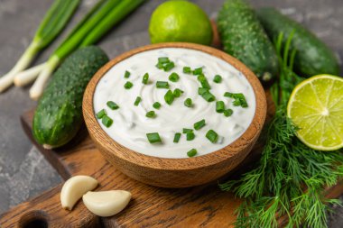 Ahşap bir masada salatalık kremalı tzatziki sosu. Tatar sosu. Geleneksel lezzetli aperatif. Yoğurt sosu. Tzatziki, salatalık, sarımsak, dereotu, limon, nane. Salata sosu. Kopya alanı.