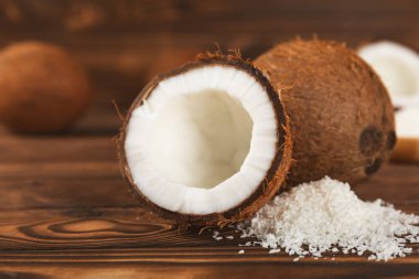 Tahta arka planda taze hindistan cevizi ve dilimler var. Hindistan cevizi gevreği. Vejetaryen. Tropik fındık, meyve. Mesaj için yer. Boşluğu kopyala.