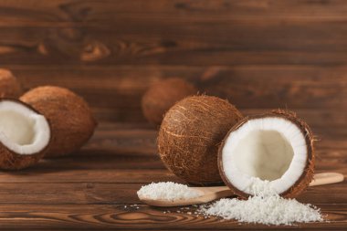 Tahta arka planda taze hindistan cevizi ve dilimler var. Hindistan cevizi gevreği. Vejetaryen. Tropik fındık, meyve. Mesaj için yer. Boşluğu kopyala.