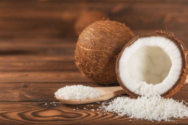 Tahta arka planda taze hindistan cevizi ve dilimler var. Hindistan cevizi gevreği. Vejetaryen. Tropik fındık, meyve. Mesaj için yer. Boşluğu kopyala.