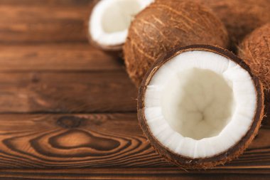 Tahta arka planda taze hindistan cevizi ve dilimler var. Hindistan cevizi gevreği. Vejetaryen. Tropik fındık, meyve. Mesaj için yer. Boşluğu kopyala.