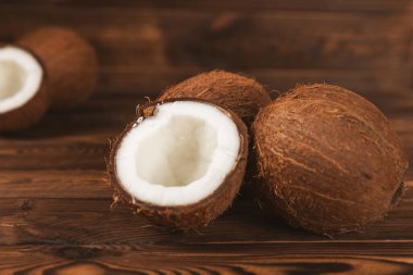 Tahta arka planda taze hindistan cevizi ve dilimler var. Hindistan cevizi gevreği. Vejetaryen. Tropik fındık, meyve. Mesaj için yer. Boşluğu kopyala.