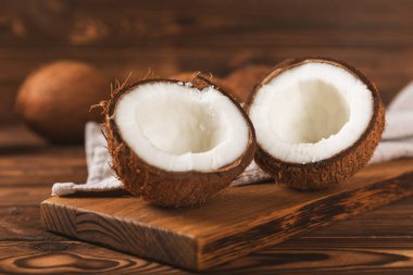 Tahta arka planda taze hindistan cevizi ve dilimler var. Hindistan cevizi gevreği. Vejetaryen. Tropik fındık, meyve. Mesaj için yer. Boşluğu kopyala.