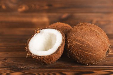 Tahta arka planda taze hindistan cevizi ve dilimler var. Hindistan cevizi gevreği. Vejetaryen. Tropik fındık, meyve. Mesaj için yer. Boşluğu kopyala.