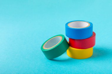 Parlak renkli arka plandaki bant yalıtılıyor. Farklı renkte izolasyon bantları. Yalıtım bandı. İnşaat aletleri. Elektrikçi aletleri. Bir parça koli bandı. Metin için boşluk. Boşluğu kopyala.