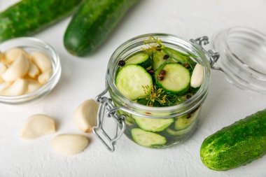 Ahşap bir arka planda kavanozda taze tuzlanmış ev yapımı salatalıklar. Dereotlu, sarımsaklı ve biberli salatalık turşusu. Konserve salatalık, salatalık ve penis. Ev yapımı koruma..