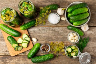 Ahşap bir arka planda kavanozda taze tuzlanmış ev yapımı salatalıklar. Dereotlu, sarımsaklı ve biberli salatalık turşusu. Konserve salatalık, salatalık ve penis. Ev yapımı koruma..