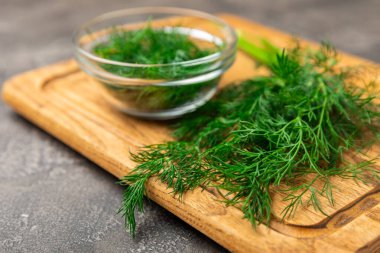 Ahşap arka planda Dill. Taze organik sebzeler. Dill çiftliği. Dereotu yapraklarını kes. Bahar genç deresi sürüsü. Vitaminler. İplik. Aromatik mutfak baharatı. Mesaj için yer. Boşluğu kopyala