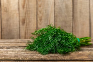 Ahşap arka planda Dill. Taze organik sebzeler. Dill çiftliği. Dereotu yapraklarını kes. Bahar genç deresi sürüsü. Vitaminler. İplik. Aromatik mutfak baharatı. Mesaj için yer. Boşluğu kopyala