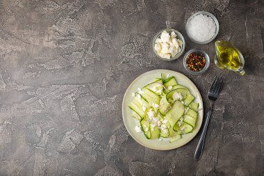 Ahşap bir arka planda salatalık. Taze sebzeli, salatalıklı, domatesli, tatlı biberli ve salatalı ev yapımı salata. Vejetaryen bahar salatası.