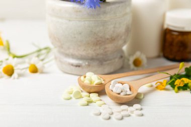 Ahşap zemin üzerinde alternatif ilaç bitkisel kapsül organik ilaç. Bitki ve tablet çeşitleri, vitaminler ve diyet takviyeleri. Sağlıklı yaşam için tıbbi ve şifalı bitkiler.