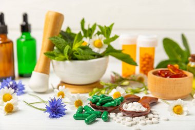 Ahşap zemin üzerinde alternatif ilaç bitkisel kapsül organik ilaç. Bitki ve tablet çeşitleri, vitaminler ve diyet takviyeleri. Sağlıklı yaşam için tıbbi ve şifalı bitkiler.