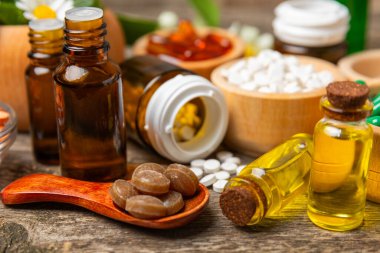 Ahşap zemin üzerinde alternatif ilaç bitkisel kapsül organik ilaç. Bitki ve tablet çeşitleri, vitaminler ve diyet takviyeleri. Sağlıklı yaşam için tıbbi ve şifalı bitkiler.