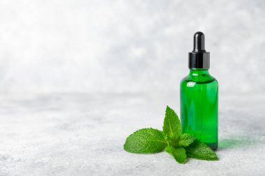 Ahşap bir arka planda esaslı bir nane şekeri. Naneli esaslı yağ ve taze nane yaprakları. Bir şişe aromaterapi yağı. Nane özütü. Doğal kozmetik konsepti, spa bakımı. Boşluğu kopyala