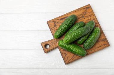 Ahşap arka planda salatalık. Arka planda bir parça salatalık. Taze organik yeşil salatalık turşusu. Vejetaryen. Salata malzemesi. Çiftlik sebzeleri. Sebzeleri bıçakla kes. Mesaj için yer var. Boşluğu kopyala