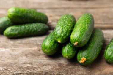 Ahşap arka planda salatalık. Arka planda bir parça salatalık. Taze organik yeşil salatalık turşusu. Vejetaryen. Salata malzemesi. Çiftlik sebzeleri. Sebzeleri bıçakla kes. Mesaj için yer var. Boşluğu kopyala