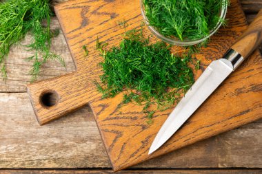 Ahşap arka planda Dill. Taze organik sebzeler. Dill çiftliği. Dereotu yapraklarını kes. Bahar genç deresi sürüsü. Vitaminler. İplik. Aromatik mutfak baharatı. Mesaj için yer. Boşluğu kopyala