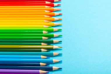 Renkli arka planda renkli kalemler. Boyama için ekipman. Yaratıcılık için kırtasiye malzemesi. Okula dönüyorum. Flatlay. Çocukların Yaratıcılığı ve Eğitimi. Rainbow.Mesaj için yer var. Boşluğu kopyala.